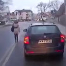 miniature pour Une femme marche sur la route, entre les voitures