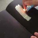miniature pour Un livre noir dont les pages se révèlent avec la chaleur