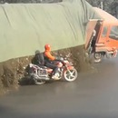 miniature pour Un camion transportant des pierres et cailloux se déverse sur un motard