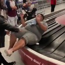 miniature pour Un homme obèse poussé sur le tapis roulant des valises