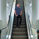 homme-coince-chaussures-escalator