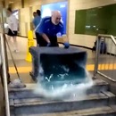 Nettoyage des escaliers du métro avec une énorme bassine d'eau savonneuse