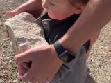 Il aide son fils à jeter une pierre